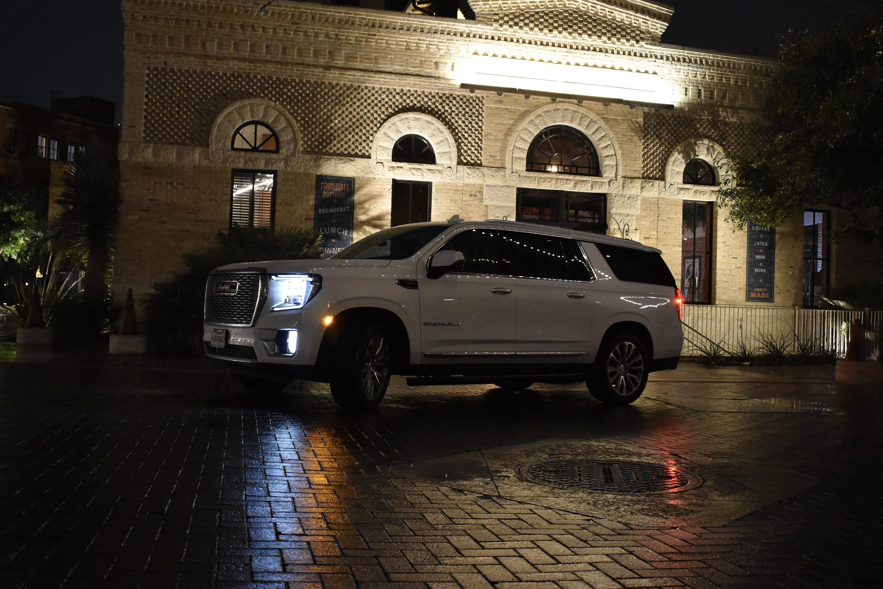 The White GMC Yukon XL Denali at night in San Antonio — our premium fleet vehicle
